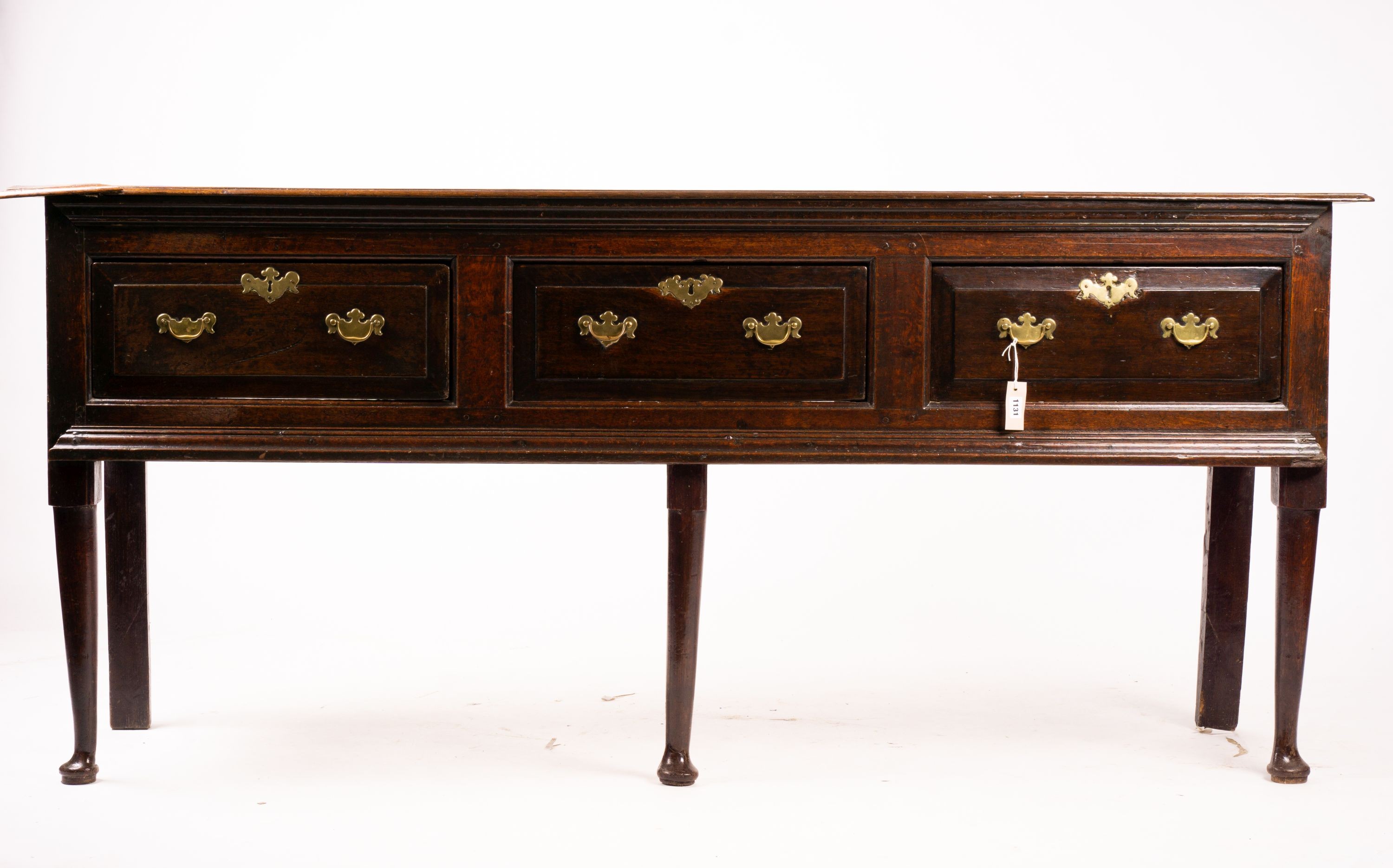 An 18th century oak low dresser on pole turned legs and pad feet, length 198cm, depth 53cm, height 88cm